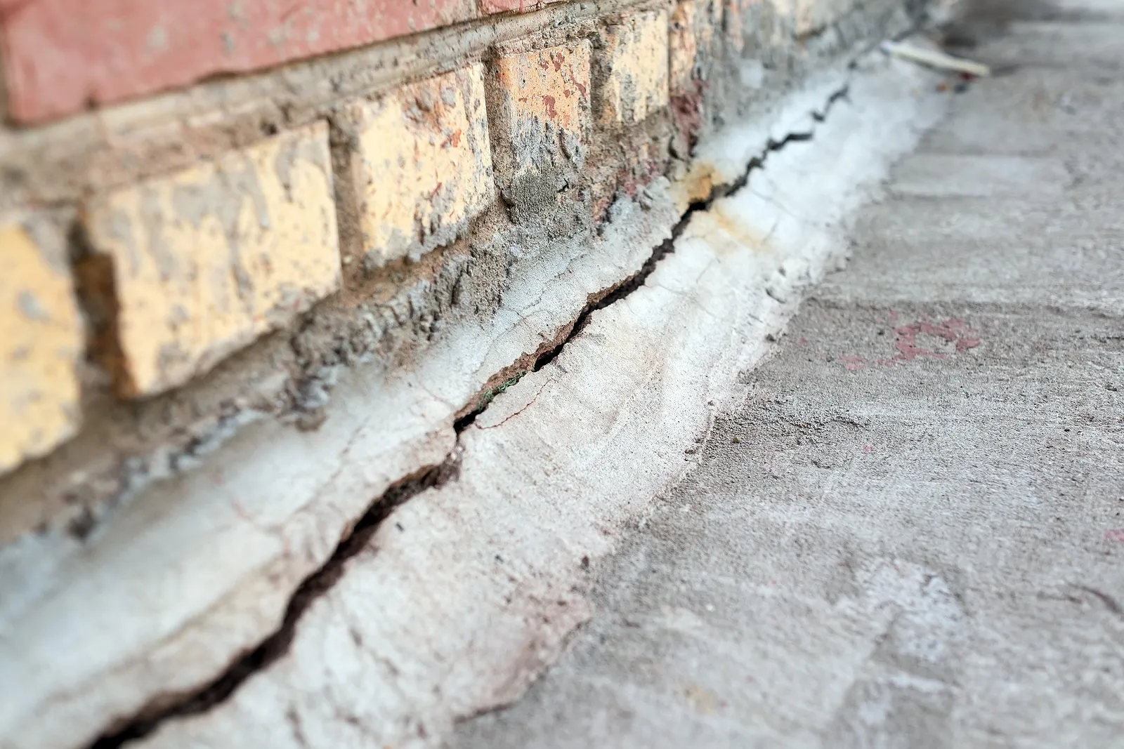 big crack in the foundation of a brick home