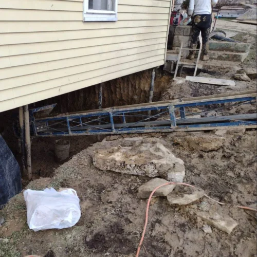 Foundation Reconstruction in Grindstone PA. Our crew has nearly completed the process of removing the soil from the partially executed basement. A conveyor belt is being used to move the soil up and out.
