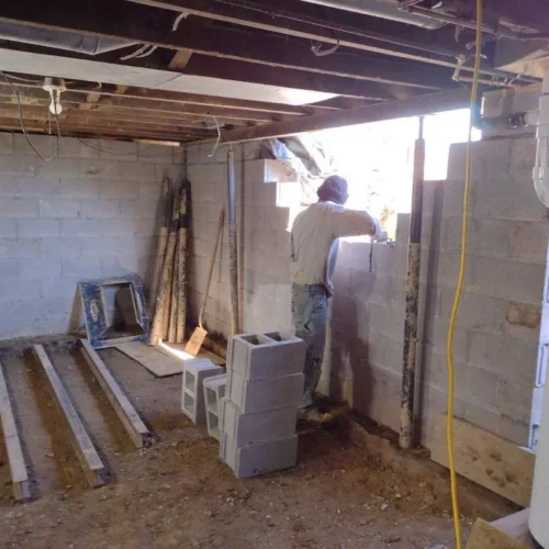The back half of this basement had previously been a partially excavated, wet and unusable space. The new footers for the new steel supports were poured today and the final block are being set. The base for the new concrete slab is also being prepared.