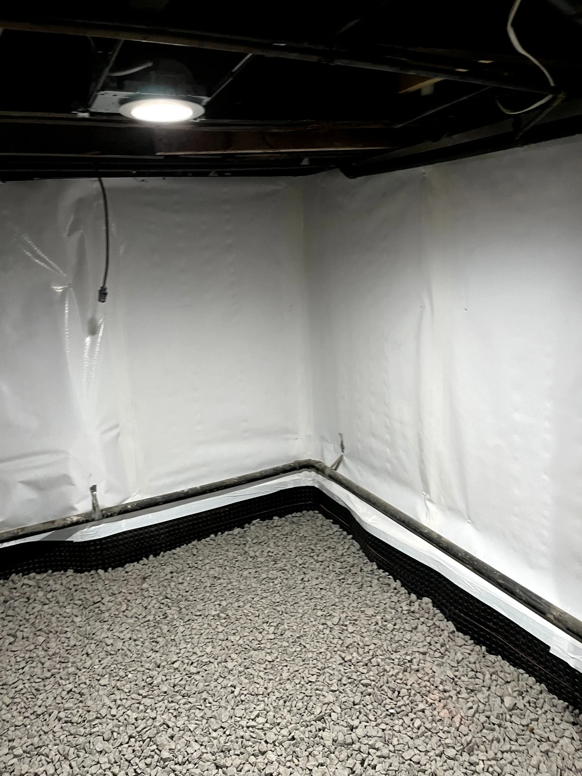 Interior basement waterproofing in progress in residential home